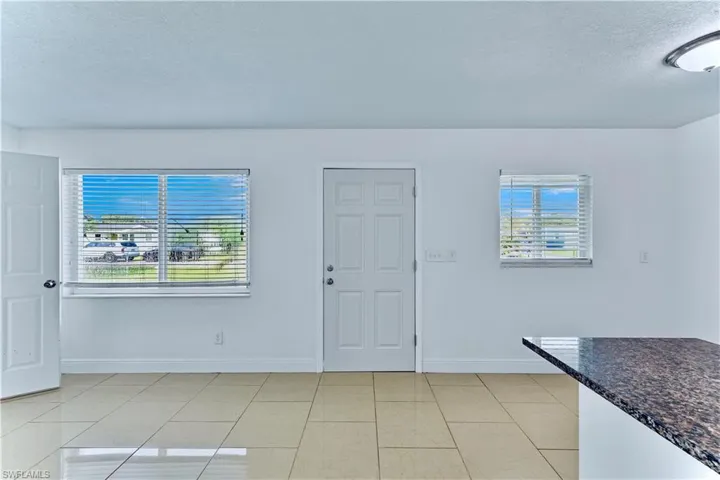 Unfurnished living room with a textured ceiling and light tile patterned flooring