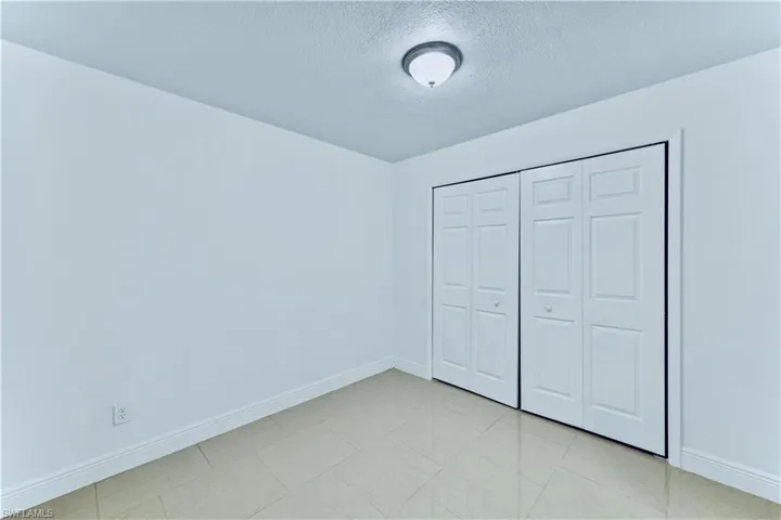 Unfurnished bedroom with a textured ceiling and a closet