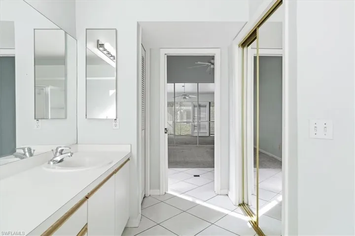 Bathroom featuring vanity, light tile patterned floors, and a closet
