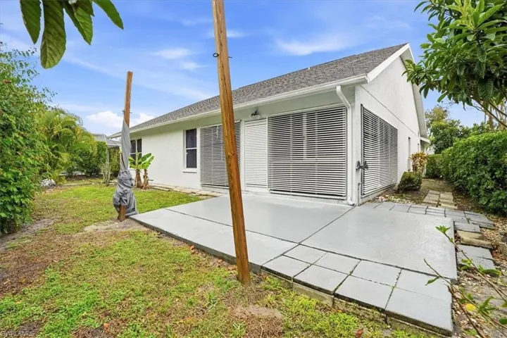 Rear view of house featuring stucco siding, a patio area, and a yard