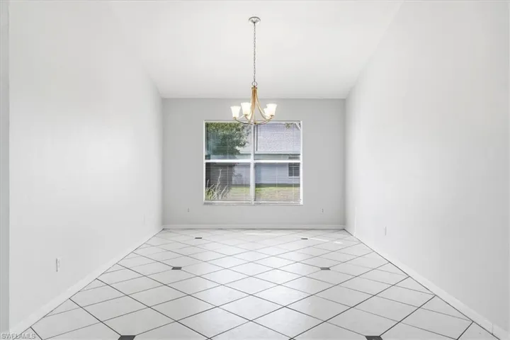 Unfurnished dining area featuring hanging lights and light tile patterned floors