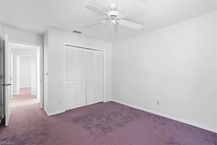 Unfurnished bedroom featuring carpet floors, a closet, and a ceiling fan