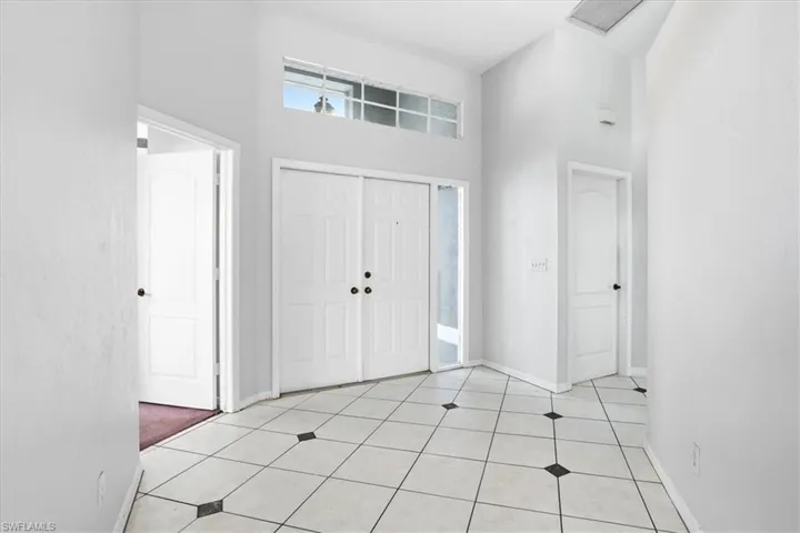 Entrance foyer featuring a high ceiling and light tile patterned floors