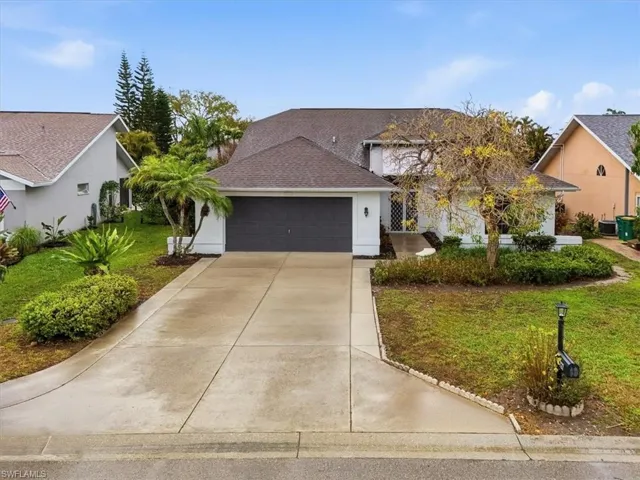 View of front of home featuring a front yard, a shingled roof, driveway, a garage, and stucco siding