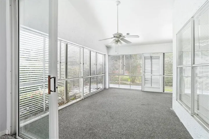 Unfurnished sunroom featuring ceiling fan and lofted ceiling
