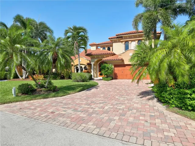 Spanish Colonial-style residence featuring a terracotta tile roof, arched entryways, and a warm stucco exterior