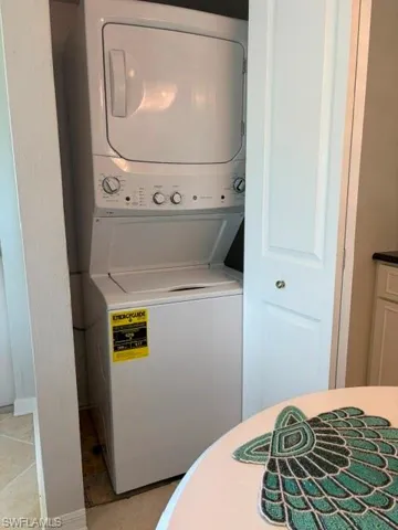 Stacked white washer and dryer unit within an integrated closet