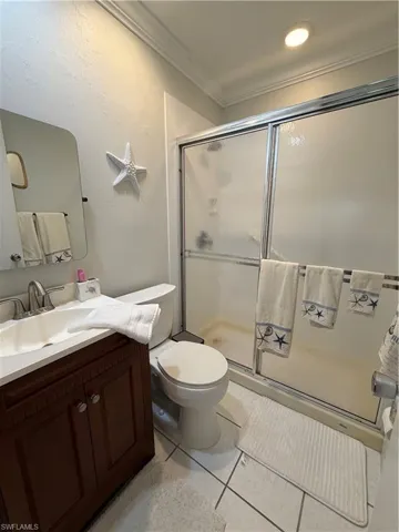 Bathroom featuring a dark wood-finish vanity with an integrated sink, polished chrome faucet, and a wall-mounted mirror