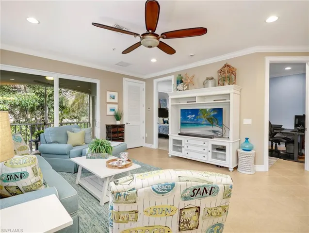 Open Great Room with Crown Molding and Sliders Leading to the Screened In Lanai with Landscaped View, Leading to the Primary Bedroom EnSuite, and Den