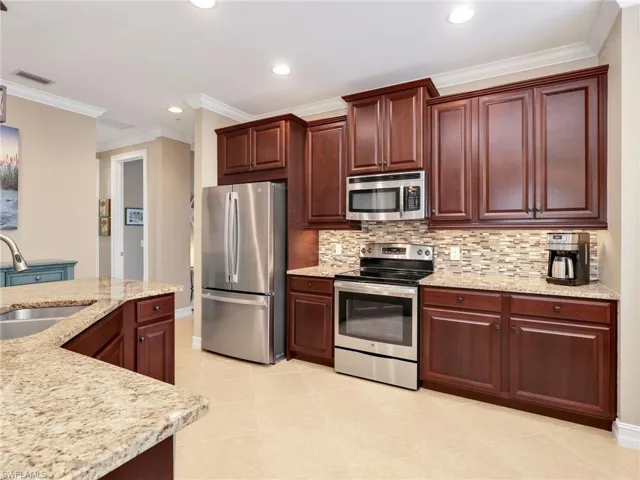 Kitchen with Granite Countertops, Breakfast Bar, 42" Solid Wood Cabinetry, Stainless Steel Appliances & Double Sink, Tile Backsplash