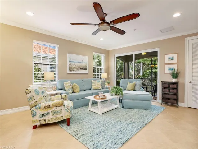 Open Great Room with Crown Molding and Sliders Leading to the Screened In Lanai with Landscaped View
