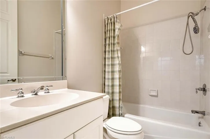 Full bathroom with shower / bath combination with curtain, vanity, and toilet