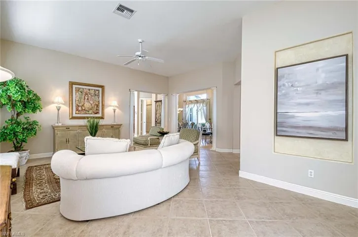 Living room with ceiling fan and light tile patterned flooring