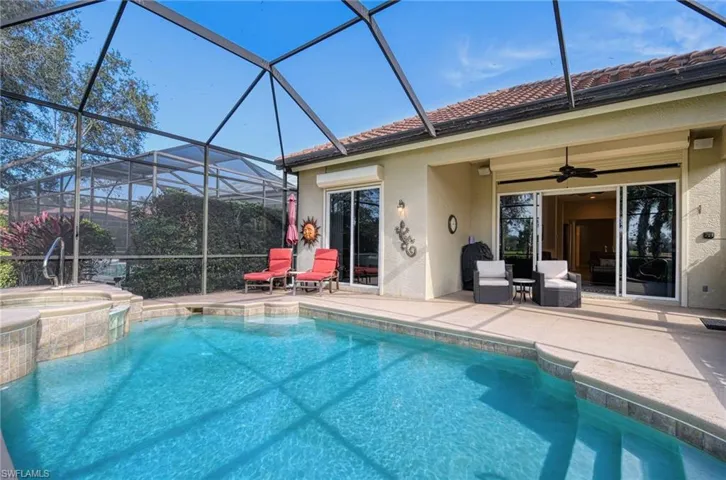 View of swimming pool with an in ground hot tub, a lanai, ceiling fan, and a patio area