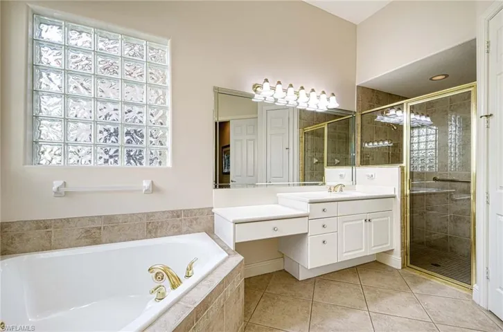 Bathroom featuring tile patterned flooring, vanity, separate shower and tub, and a wealth of natural light
