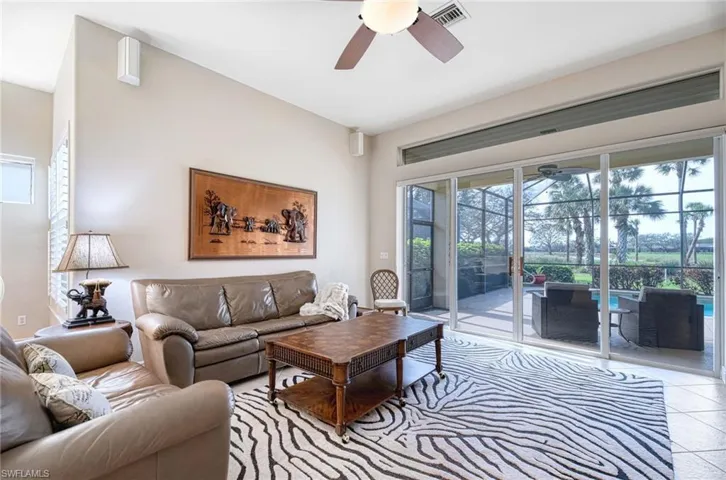 Living room featuring light tile patterned floors and ceiling fan