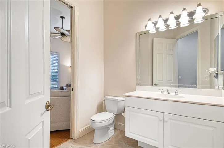Bathroom featuring tile patterned floors, ceiling fan, toilet, and vanity