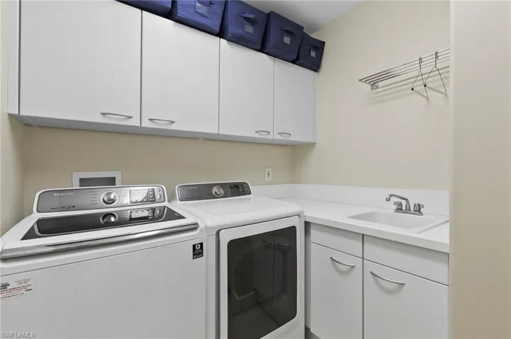 Laundry area featuring washing machine and clothes dryer and cabinet space