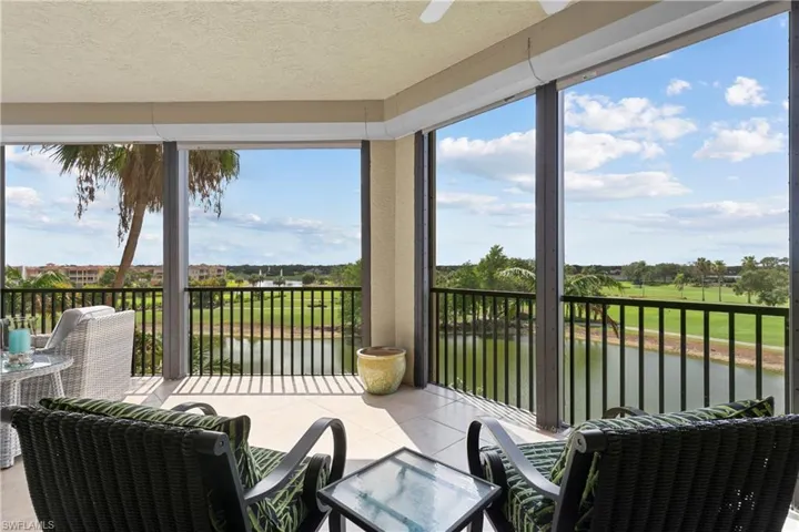 Sunroom with a water view, a textured ceiling, tile patterned floors, golf course view, and healthy amount of natural light