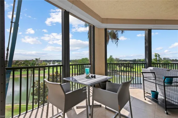 Wrap around lanai featuring tile patterned flooring, a water view, healthy amount of natural light, a textured ceiling, and outdoor dining space