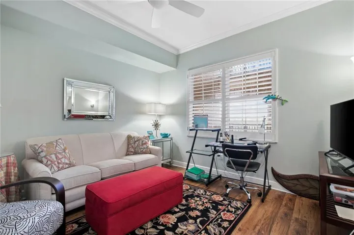 Living area featuring crown molding, a ceiling fan, and wood finished floors