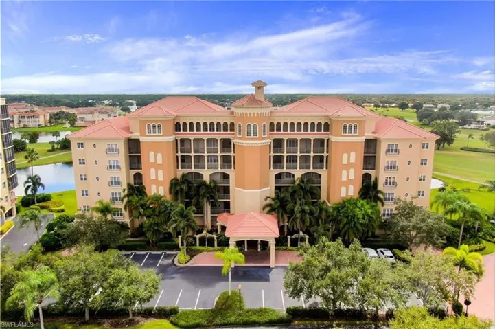 View of apartment building / complex with uncovered parking and a water view