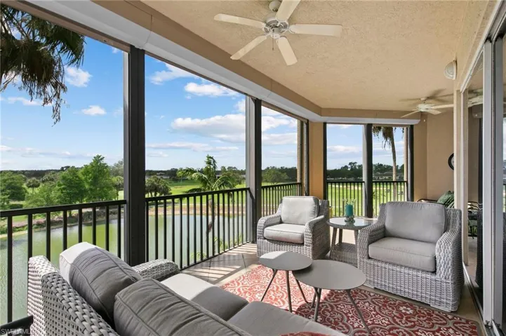 Sunroom / solarium with a ceiling fan and a water view