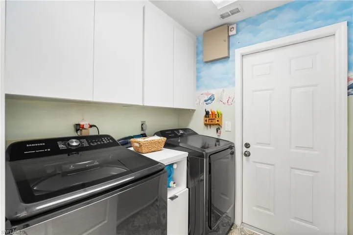 Laundry room with cabinets and separate washer and dryer