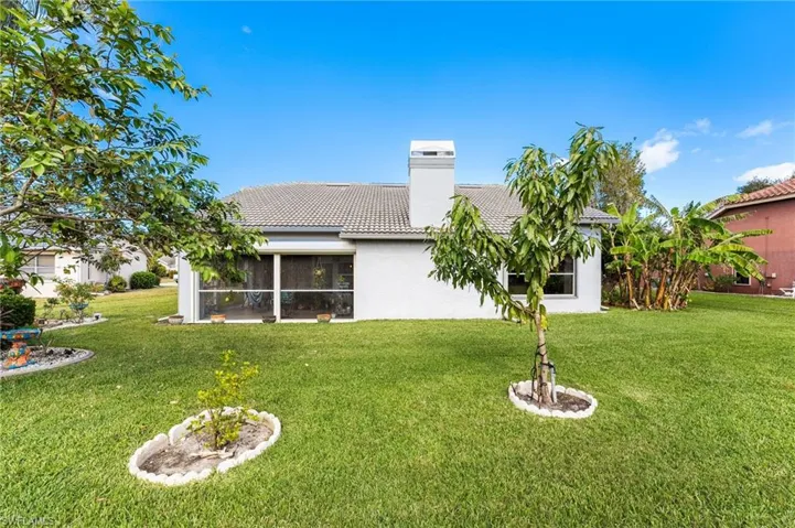 Back of property with a yard and a sunroom