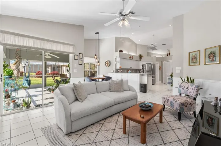 Tiled living room featuring high vaulted ceiling and sink