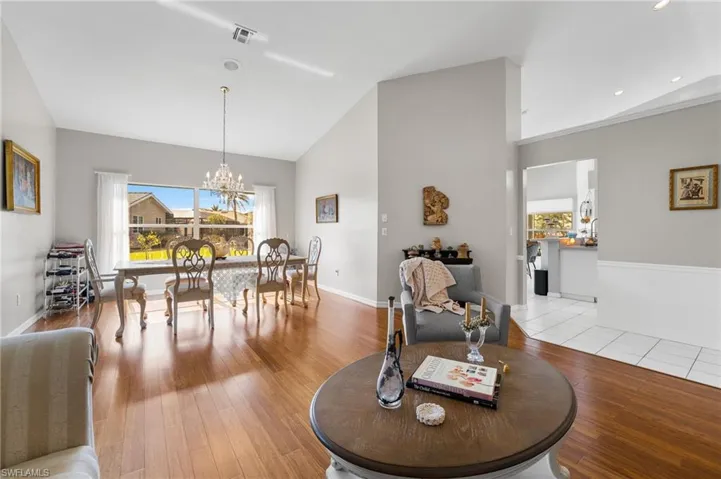 Dining area featuring light hardwood / wood-style floors, lofted ceiling, and a chandelier