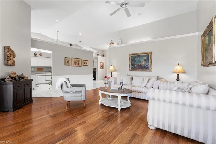 Living room featuring hardwood / wood-style floors, ceiling fan, and lofted ceiling
