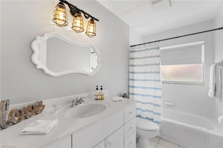 Full bathroom featuring tile patterned flooring, vanity, shower / bath combo, and toilet