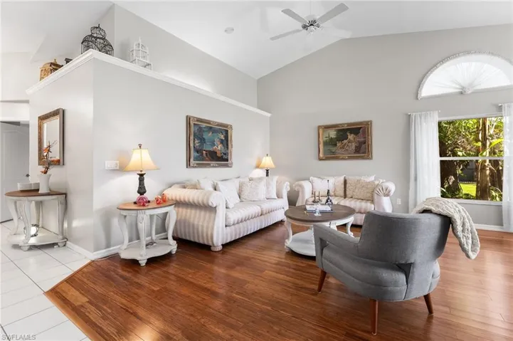 Living room featuring ceiling fan, high vaulted ceiling, and wood-type flooring