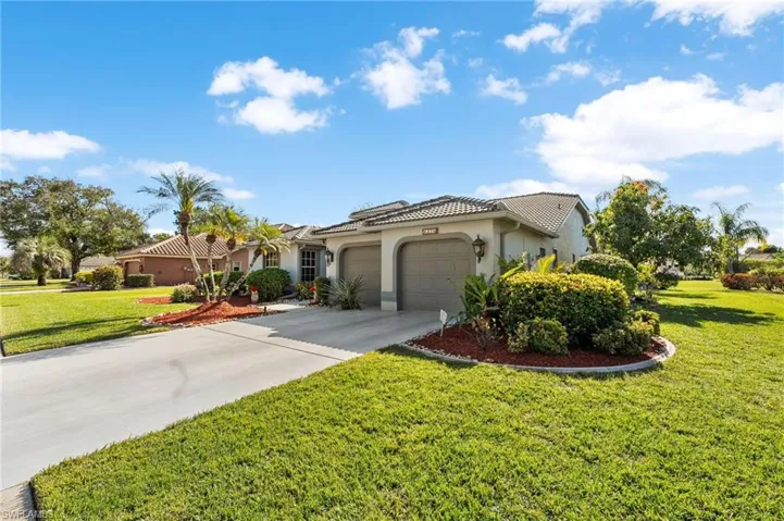 Mediterranean / spanish-style house with a garage and a front lawn