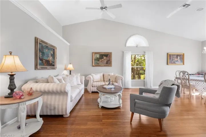 Living room featuring hardwood / wood-style flooring, ceiling fan, and lofted ceiling