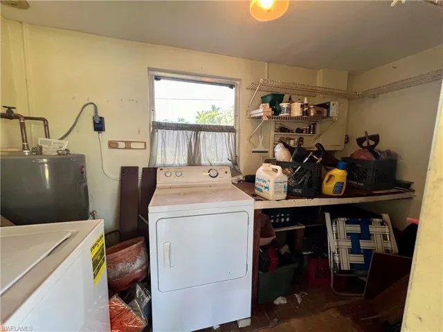 Laundry room featuring water heater and washing machine and clothes dryer