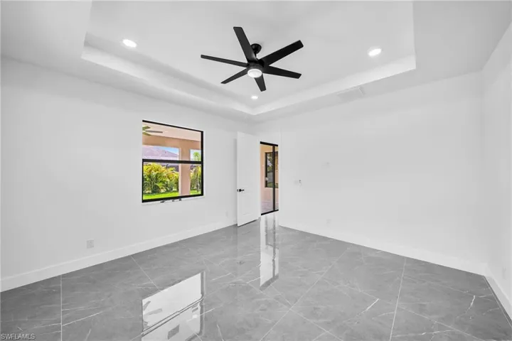 Unfurnished room with a raised ceiling and ceiling fan