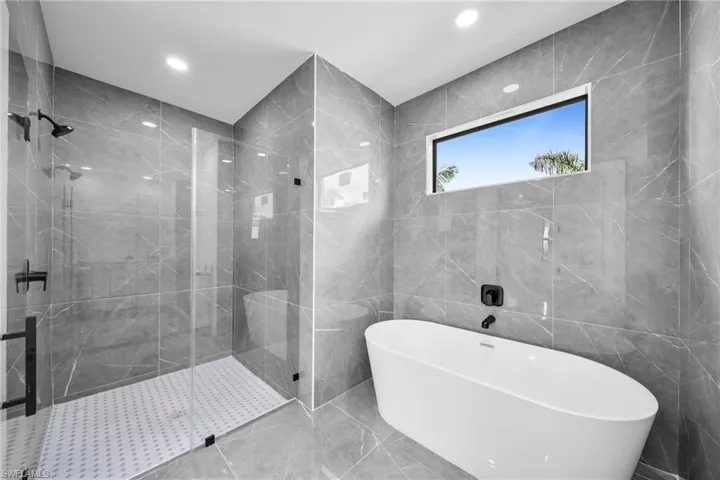 Bathroom with tile walls and plus walk in shower