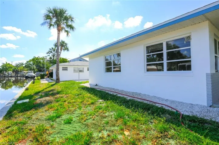 View of side of home featuring a yard and a water view