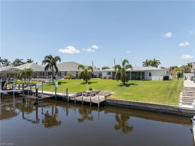 Dock area with a water view and a yard