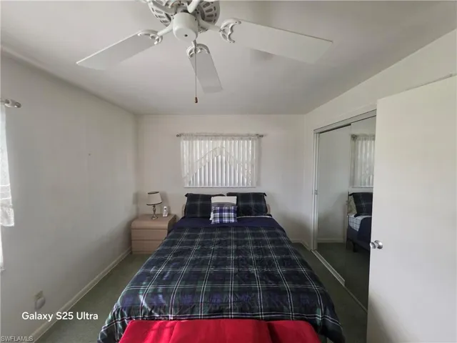 Carpeted bedroom featuring a ceiling fan, baseboards, and a closet