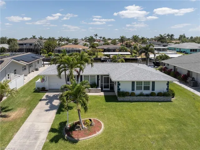 Single story home with driveway, a residential view, a garage, and a front lawn