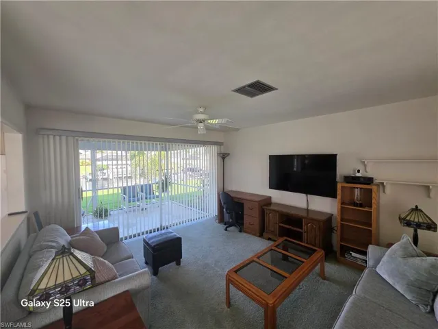 Living room featuring a ceiling fan, carpet, and visible vents