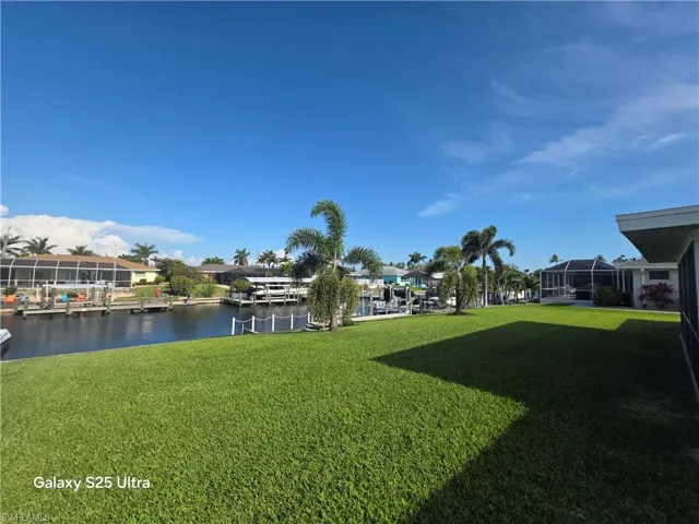 View of yard with a water view and a dock