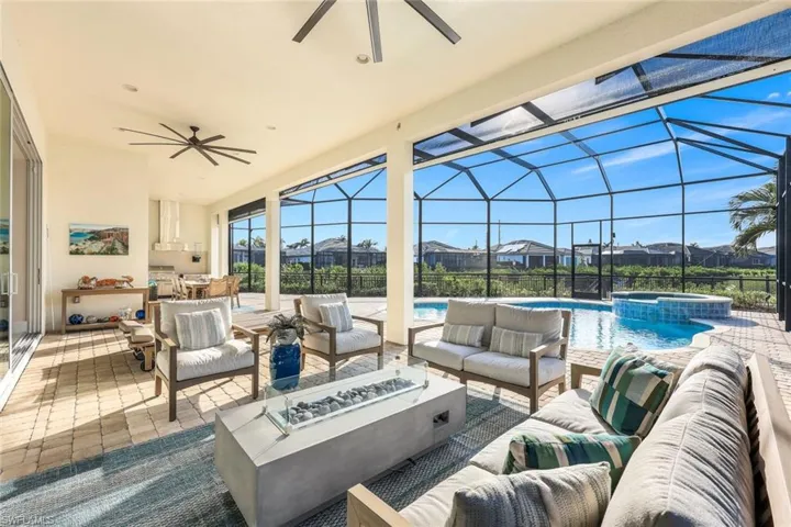 View of patio / terrace with a swimming pool with hot tub, an outdoor living space with a fire pit, a lanai, and ceiling fan