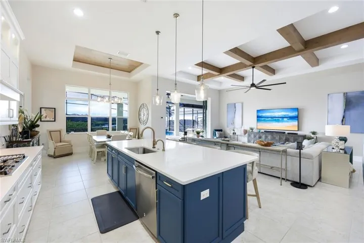 Kitchen featuring blue cabinets, white cabinets, pendant lighting, and appliances with stainless steel finishes