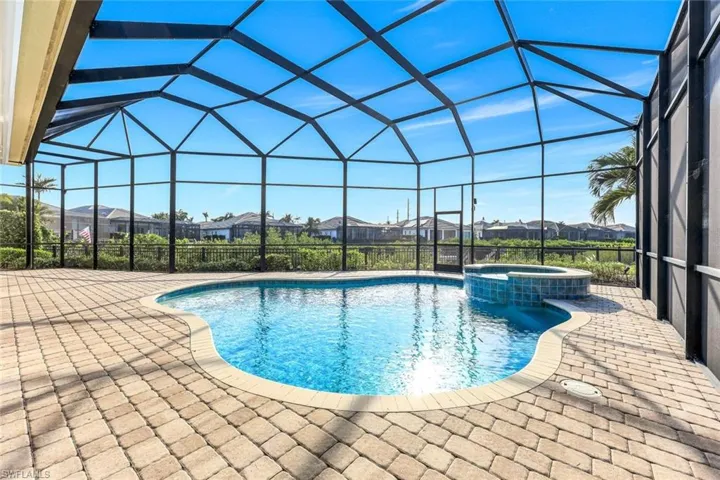 View of swimming pool featuring an in ground hot tub, a patio, and a lanai