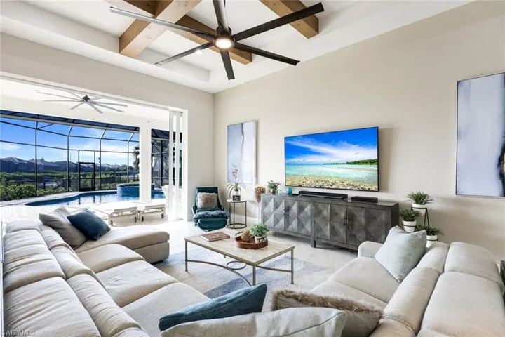 Tiled living room featuring beamed ceiling, ceiling fan, a mountain view, and coffered ceiling