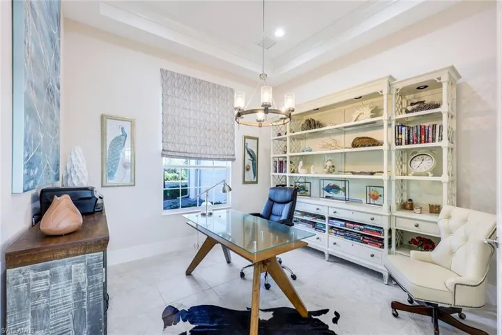 Office with a tray ceiling, crown molding, and a notable chandelier